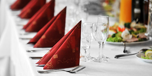 special-events A row of napkins and glasses on a banquet table
